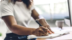 Personne en posture calme, concentrée, en train d’écrire — réflexion intérieure